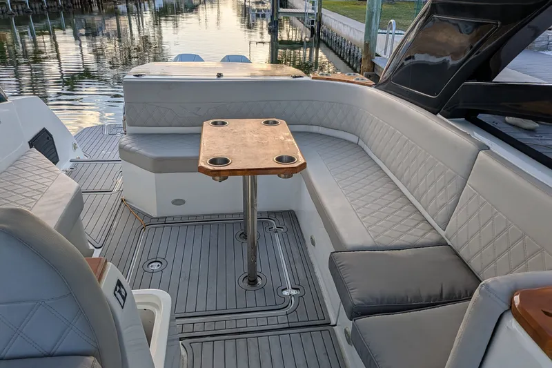 Slide: The Image of 2023 NX Boats 340 Sport Coupe interior with elegant seating and wooden table. - 20