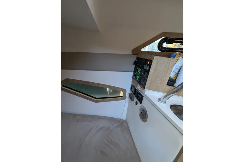 Slide: The Image of Interior of 2023 NX Boats 340 Sport Coupe, featuring control panel and window. - 32