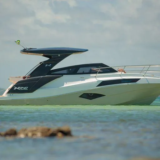 Slide: The Image of Manufacturer Provided Image: 2023 NX Boats 340 Sport Coupe on tranquil water, side view. - 16