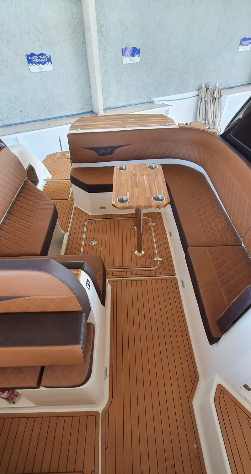 Slide: The Image of Manufacturer Provided Image: 2023 NX Boats 340 Sport Coupe interior with elegant wood finish and seating area. - 18