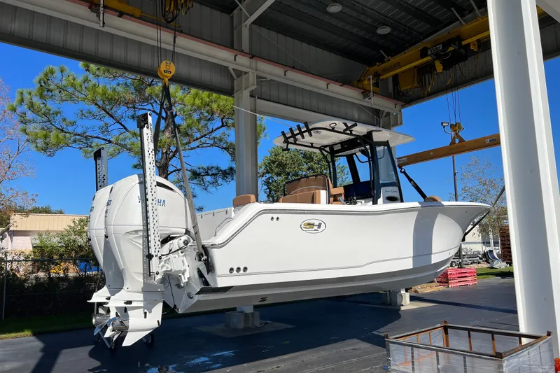 Slide: The Image of 2025 Sea Hunt Gamefish 27FS boat suspended in a covered dock area. - 2