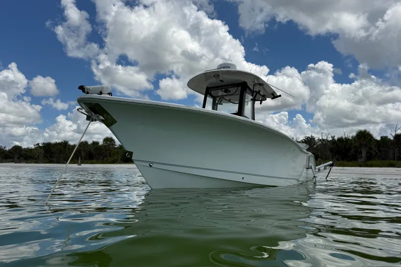 Slide: The Image of 2025 Sea Hunt Gamefish 27FS boat on calm water under cloudy sky. - 6