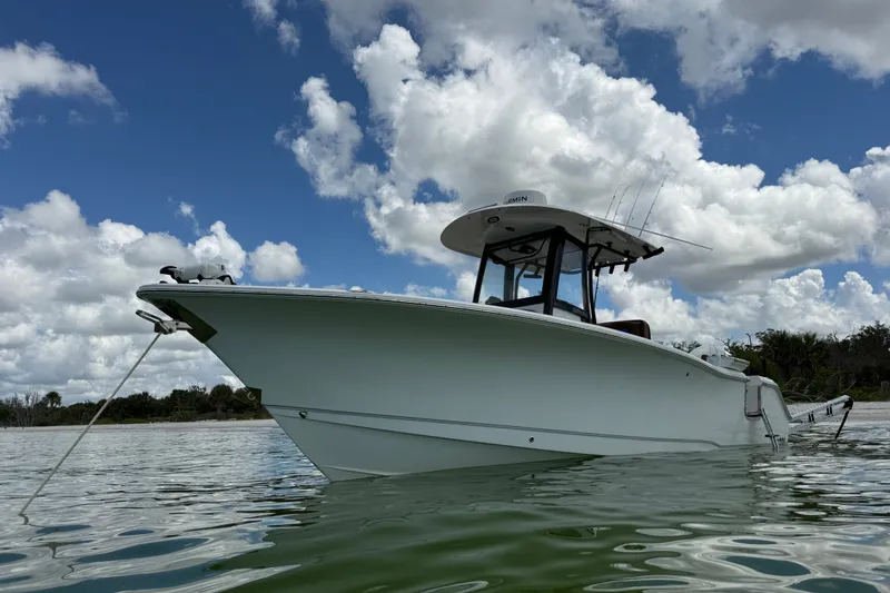 Slide: The Image of 2025 Sea Hunt Gamefish 27FS boat on calm water under a cloudy sky. - 7