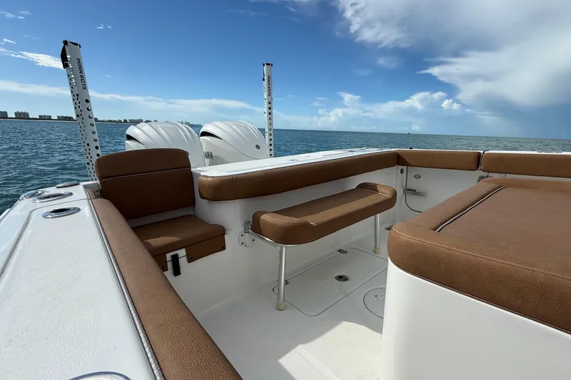 Slide: The Image of 2025 Sea Hunt Gamefish 27FS boat interior with brown seating, ocean view, and dual engines. - 18