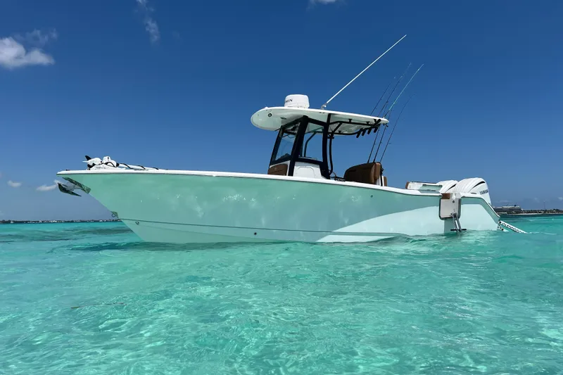 Slide: The Image of 2025 Sea Hunt Gamefish 27FS boat on clear turquoise water under blue sky. - 58