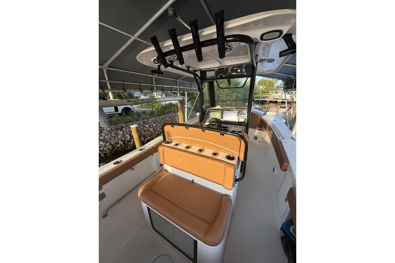 Slide: The Image of 2025 Sea Hunt Gamefish 27FS boat interior with tan seating and fishing rod holders. - 20
