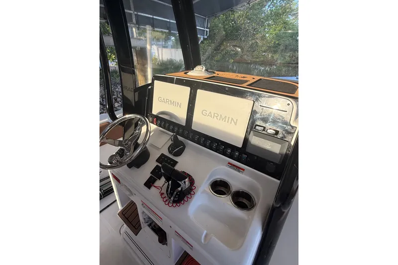 Slide: The Image of 2025 Sea Hunt Gamefish 27FS helm with Garmin displays and steering wheel. - 32