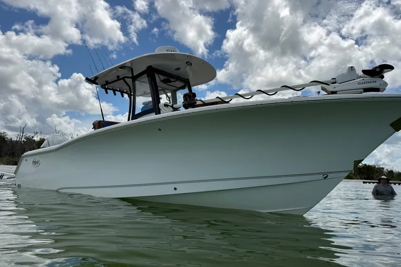 Slide: The Image of 2025 Sea Hunt Gamefish 27FS boat on water under cloudy sky. - 8