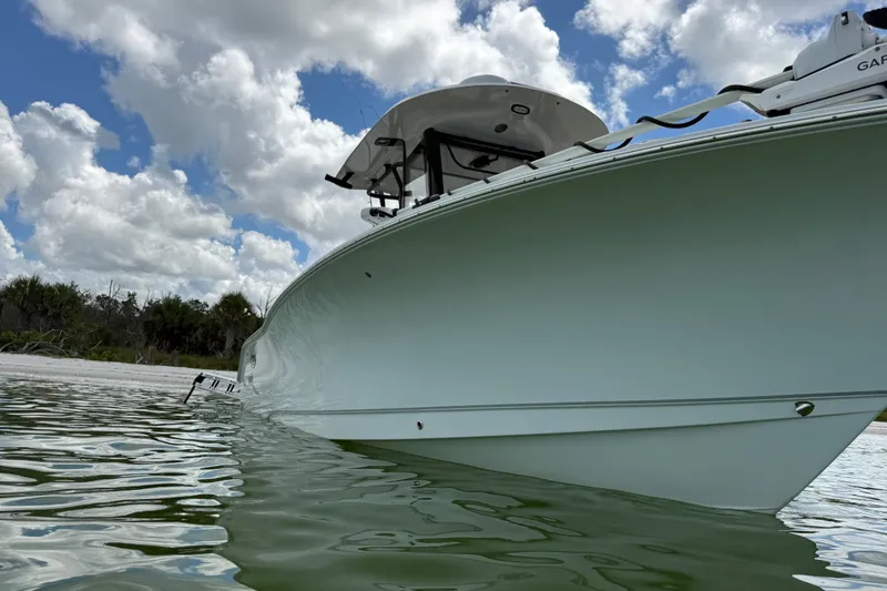 Slide: The Image of 2025 Sea Hunt Gamefish 27FS boat on calm water under a cloudy sky. - 9
