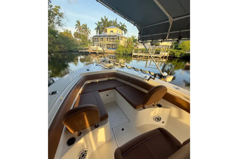 Slide: The Image of 2025 Sea Hunt Gamefish 27FS boat interior with brown seating, dockside view. - 21