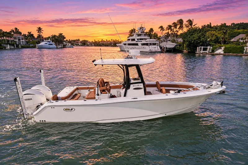 The Image of 2025 Sea Hunt Gamefish 27FS boat cruising at sunset in a scenic marina. - 0