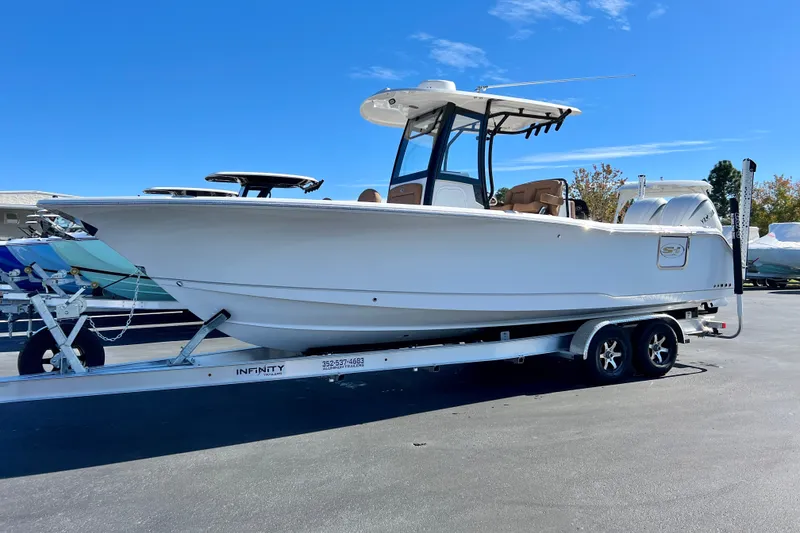 Slide: The Image of 2025 Sea Hunt Gamefish 27FS boat on trailer under clear blue sky. - 0