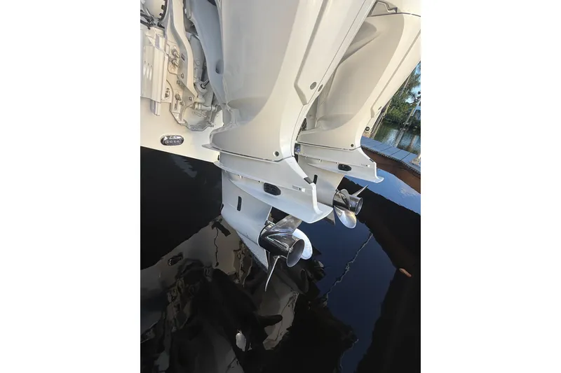 Slide: The Image of Twin outboard motors on a 2025 Sea Hunt Gamefish 27FS boat, reflecting on water. - 14