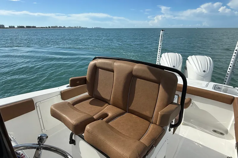 Slide: The Image of 2025 Sea Hunt Gamefish 27FS boat interior with brown seating, ocean view. - 19
