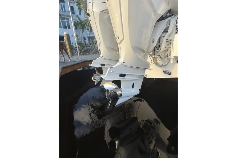 Slide: The Image of 2025 Sea Hunt Gamefish 27FS boat engines with dual propellers, docked near a waterfront. - 12