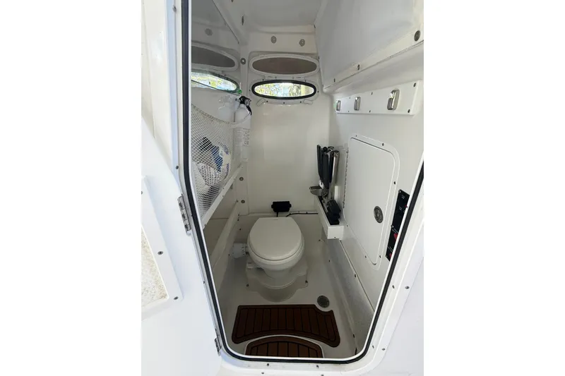 Slide: The Image of Interior of 2025 Sea Hunt Gamefish 27FS boat, featuring compact marine toilet and storage. - 38