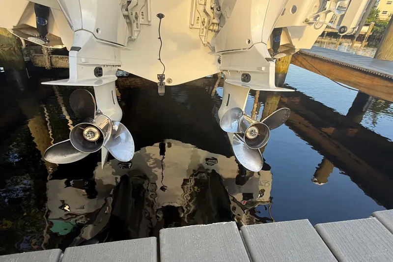 Slide: The Image of Twin propellers of a 2025 Sea Hunt Gamefish 27FS boat, docked by the water. - 13