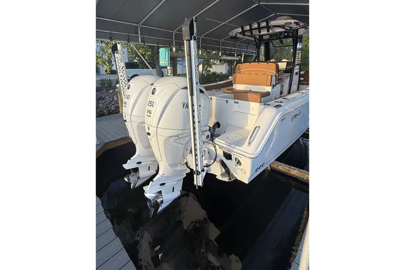Slide: The Image of 2025 Sea Hunt Gamefish 27FS boat with dual Yamaha 250 engines, docked under a canopy. - 11
