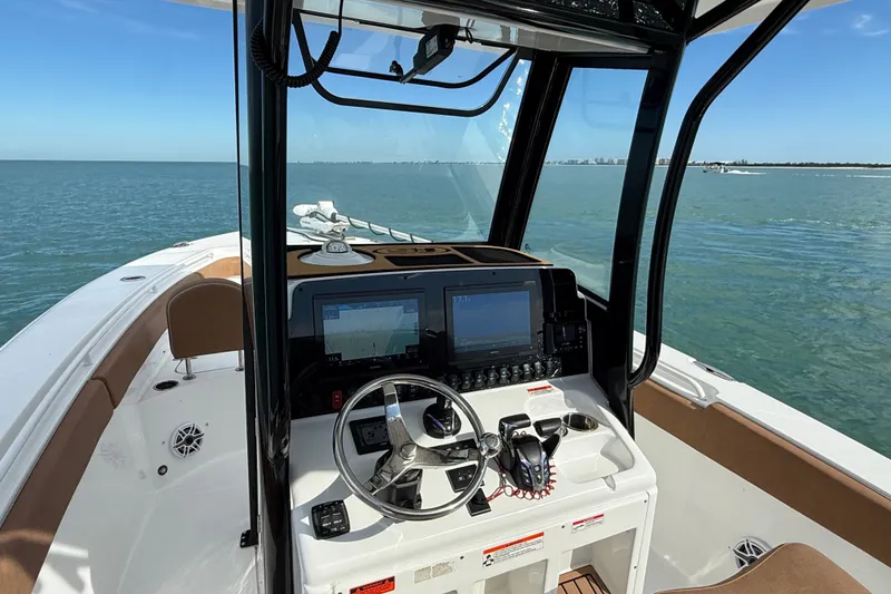 Slide: The Image of 2025 Sea Hunt Gamefish 27FS boat interior with navigation system on calm waters. - 29