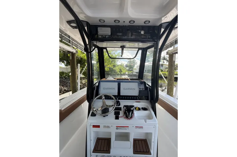 Slide: The Image of 2025 Sea Hunt Gamefish 27FS boat cockpit with Garmin navigation system and steering wheel. - 31