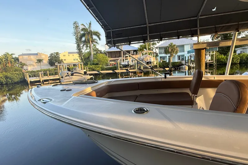 Slide: The Image of 2025 Sea Hunt Gamefish 27FS boat docked in a serene waterfront setting. - 27