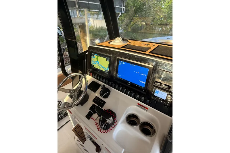 Slide: The Image of Helm of 2025 Sea Hunt Gamefish 27FS with advanced navigation displays and controls. - 30