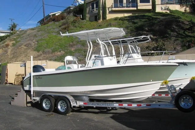 Slide: The Image of 2016 Edgewater 208CC boat on trailer, parked outdoors near hillside. - 11