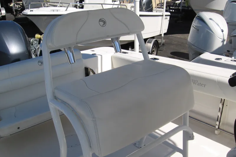 Slide: The Image of 2016 Edgewater 208CC boat interior with white seating and engine view. - 5