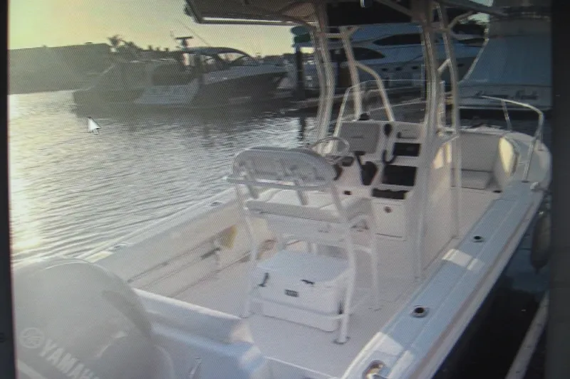 Slide: The Image of 2016 Edgewater 208CC boat docked at marina during sunset, featuring Yamaha engine. - 2