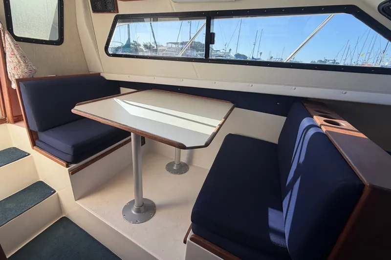 Slide: The Image of Interior of 1994 Skipjack 262 Flybridge boat with dining area and blue seating. - 20