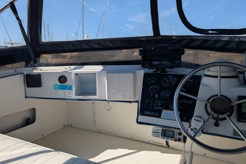 Slide: The Image of 1994 Skipjack 262 Flybridge boat cockpit with steering wheel and control panel. - 17