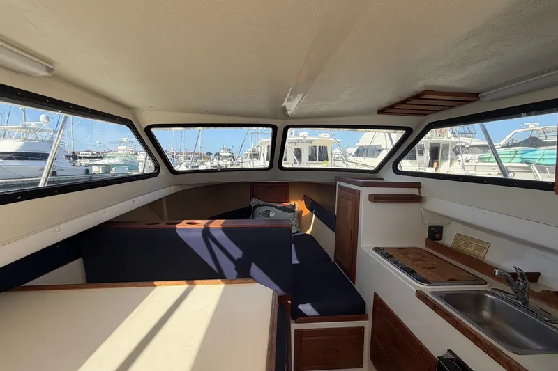 Slide: The Image of Interior of 1994 Skipjack 262 Flybridge boat with seating and kitchenette, docked at marina. - 19