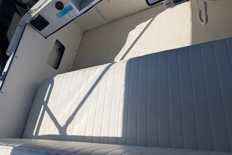 Slide: The Image of Interior of a 1994 Skipjack 262 Flybridge boat with white cushioned seating. - 51