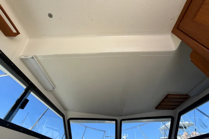 Slide: The Image of Interior view of a 1994 Skipjack 262 Flybridge boat, showcasing ceiling and windows. - 30