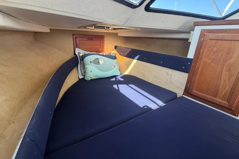Slide: The Image of Interior of the 1994 Skipjack 262 Flybridge with blue upholstery and wooden cabinetry. - 22