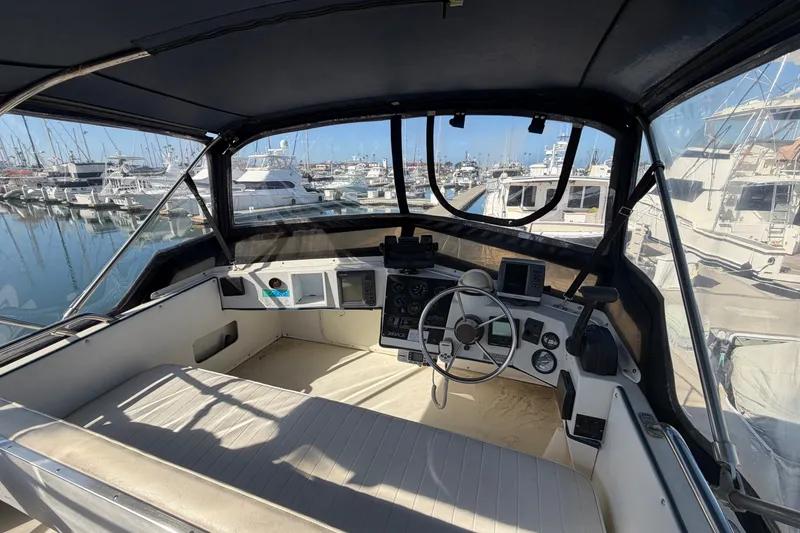 Slide: The Image of Flybridge view of 1994 Skipjack 262 boat, docked in a marina with clear skies. - 14