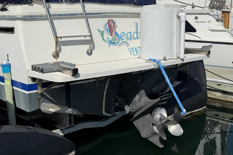 Slide: The Image of 1994 Skipjack 262 Flybridge boat stern with propeller and ladder at marina. - 33