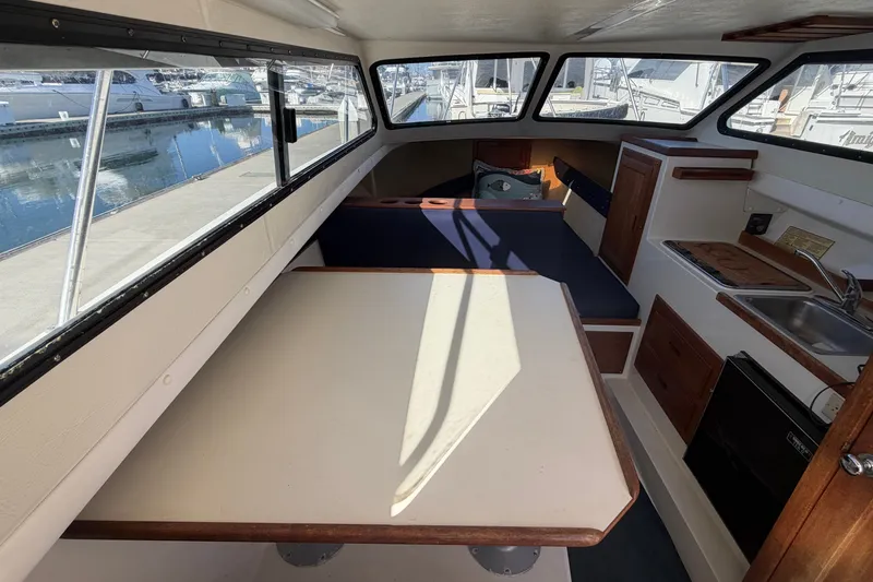Slide: The Image of Interior of a 1994 Skipjack 262 Flybridge boat with seating and kitchenette. - 18
