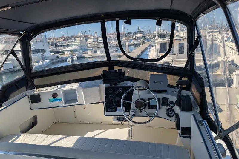 Slide: The Image of 1994 Skipjack 262 Flybridge boat interior with steering wheel and navigation equipment at marina. - 14