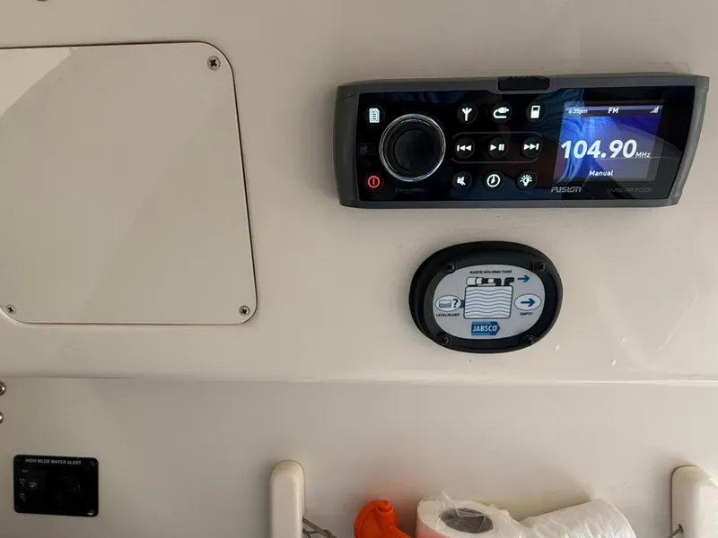 Slide: The Image of A Fusion audio system and Jabsco control panel are mounted on a boat's wall. - 34