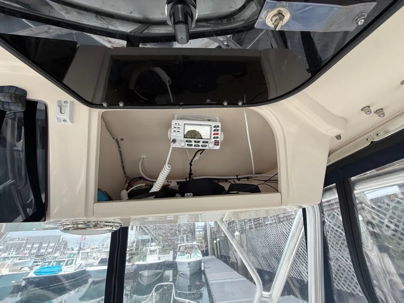 Slide: The Image of An electronic device is mounted in a compartment above the helm of a boat. - 25