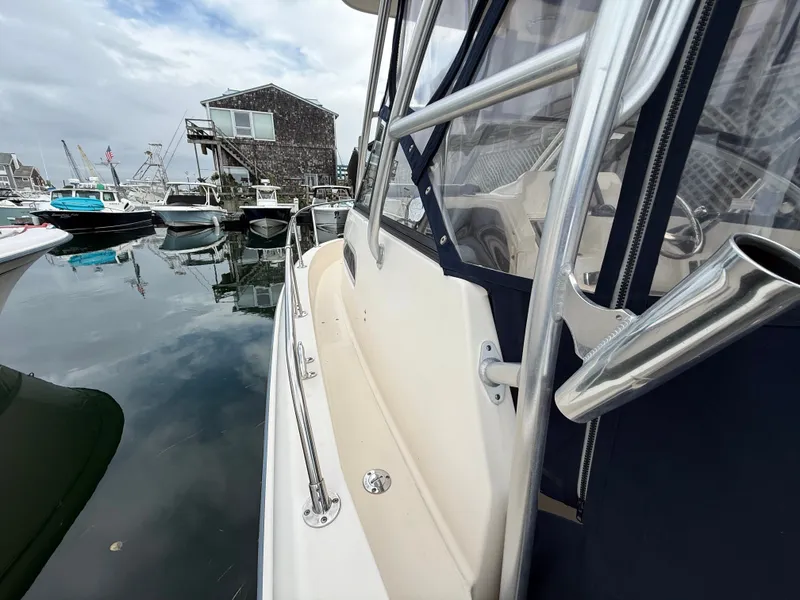 Slide: The Image of 2015 Grady-White Gulfstream 232 docked, surrounded by other boats and a building. - 11