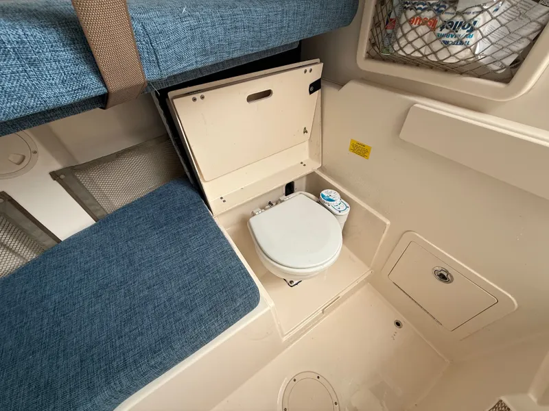 Slide: The Image of Interior of a 2015 Grady-White Gulfstream 232 with a toilet and blue upholstery. - 31