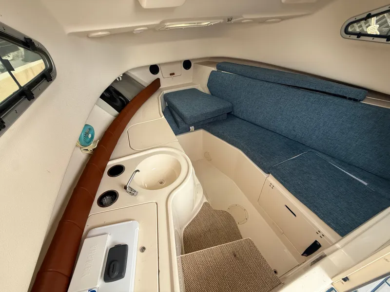 Slide: The Image of Interior of the Grady-White Gulfstream 232 with blue upholstery and a sink. - 28