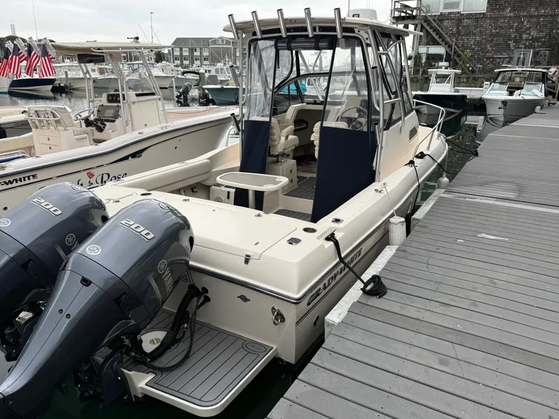 Slide: The Image of 2015 Grady-White Gulfstream 232 docked, featuring twin outboard engines and a spacious cockpit. - 7
