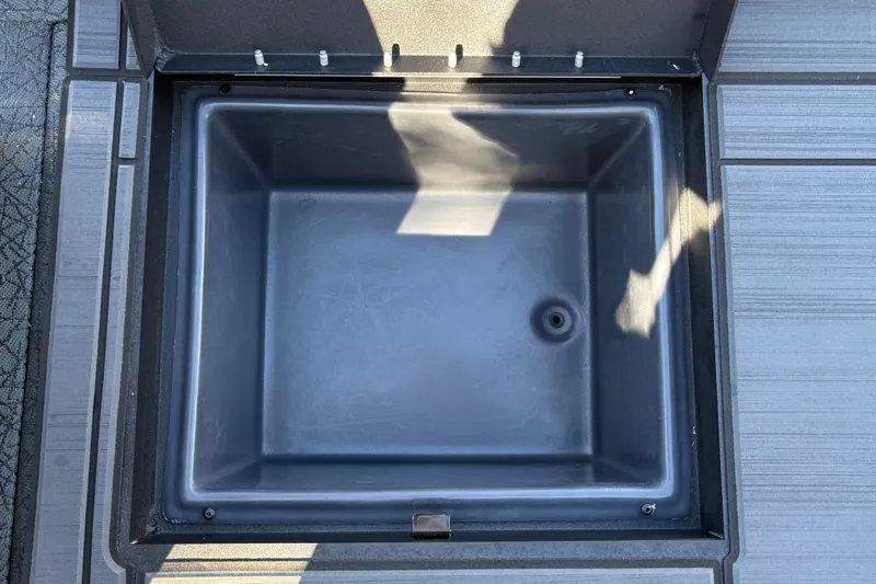 Slide: The Image of Open storage compartment in 2027 Tracker Savage 215 boat, featuring a sleek, modern design. - 27