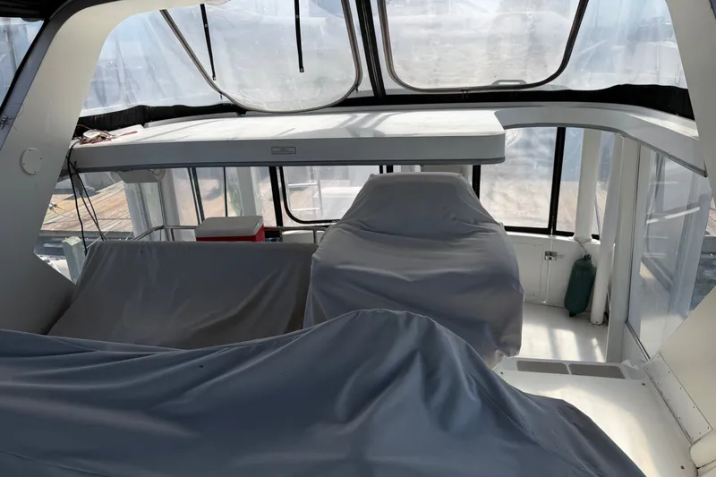 Slide: The Image of 1997 Carver 445 Aft Cabin Motor Yacht interior with covered seating and panoramic windows. - 27