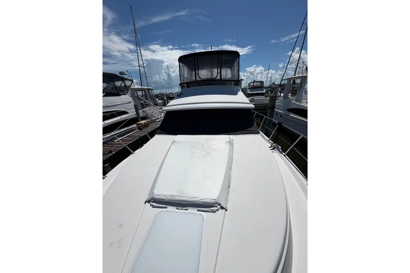 Slide: The Image of 1997 Carver 445 Aft Cabin Motor Yacht docked under a clear blue sky. - 30