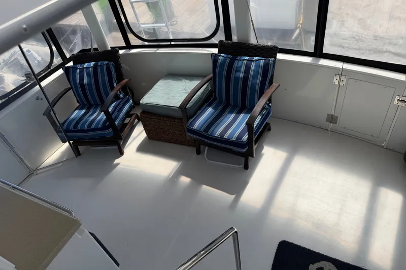 Slide: The Image of Interior of 1997 Carver 445 Aft Cabin Motor Yacht with striped chairs and ottoman. - 26