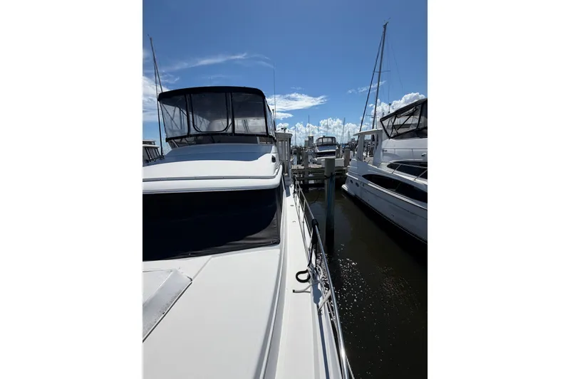 Slide: The Image of 1997 Carver 445 Aft Cabin Motor Yacht docked at marina under clear blue sky. - 28